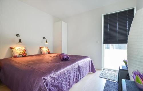 a bedroom with a bed with purple sheets and a window at Amazing Home In Nimtofte With Wifi in Nimtofte