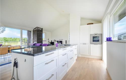 a kitchen with white cabinets and a large window at Amazing Home In Nimtofte With Wifi in Nimtofte