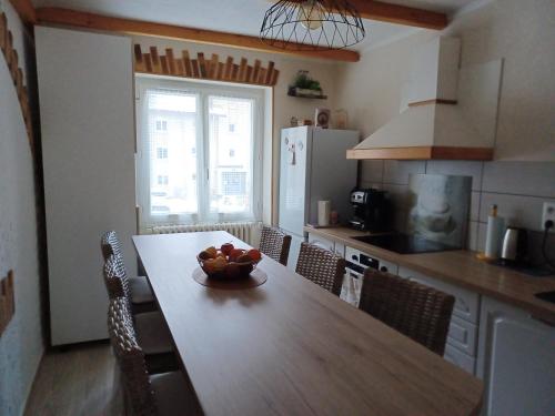 une cuisine avec une table avec un bol de fruits dessus dans l'établissement Appartement 5 pers, LA VANOISE, GARAGE motos vélos, à Fourneaux