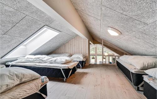 SpottrupにあるStunning Home In Spttrup With 12 Bedrooms, Sauna And Wifiのベッド3台と窓が備わる屋根裏部屋