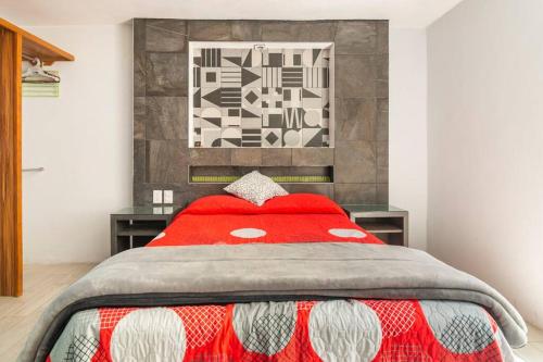 a bedroom with a red comforter on a bed at Habitación Donovan, confortable con baño privado in Mexico City