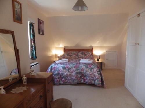 a bedroom with a bed and a dresser and two lamps at Crow Corner in Yoxford