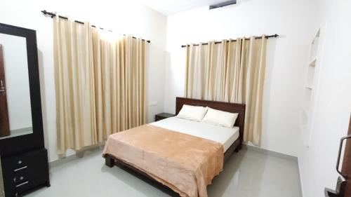 Eve's appartment في Meppādi: غرفة نوم بسرير ونافذة كبيرة