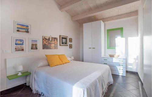 een witte slaapkamer met een bed met een geel kussen bij Stunning Home In Ragusa With Kitchen in Ragusa