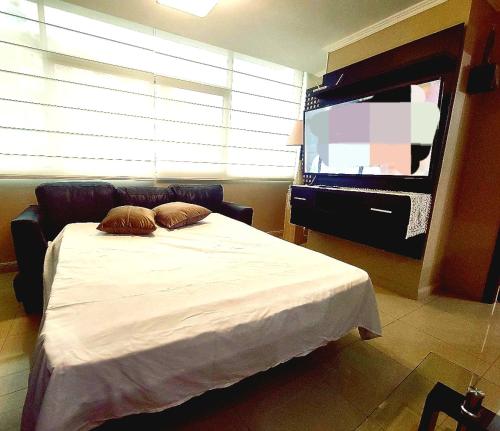 1 dormitorio con 1 cama y TV de pantalla plana en Suite en Puerto Santana, en Guayaquil