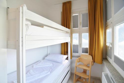 1 Schlafzimmer mit 2 Etagenbetten und einem Stuhl in der Unterkunft Hamburg App. 06 in Ahlbeck