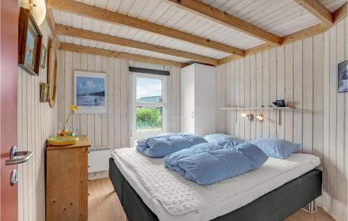 um quarto com uma cama com almofadas azuis e uma janela em Lovely Home In Hjrring With Wifi em Hjørring