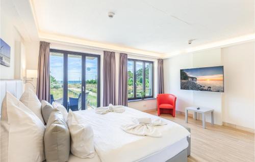 a white bedroom with a large bed and a red chair at Skipper in Binz