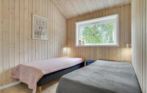 a bedroom with two beds and a window at Beautiful Home In Idestrup With Kitchen in Marielyst