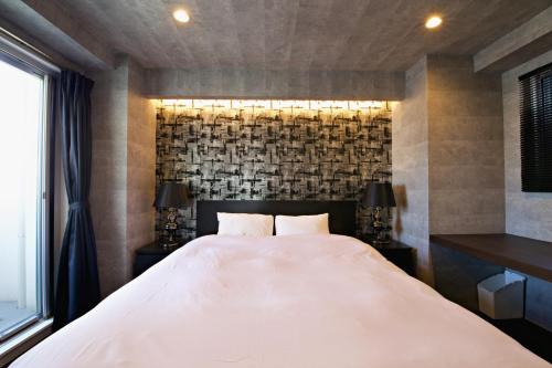 um quarto com uma grande cama branca e uma janela em Regalo shibaura 801 em Tóquio