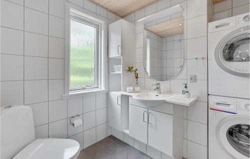 a white bathroom with a washing machine and a sink at Perlan in Snogebæk