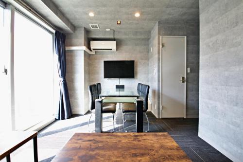 Habitación con escritorio con sillas y TV. en Regalo shibaura 801, en Tokio