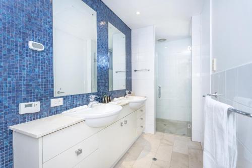 a bathroom with two sinks and a mirror at Cottesloe Beach Haven in Perth