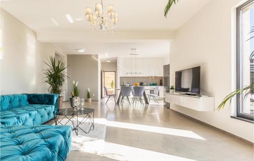 ein Wohnzimmer mit einer blauen Couch und einer Küche in der Unterkunft Beautiful Home In Glavina Donja in Donja Glavina