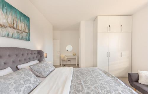 een slaapkamer met een groot bed en een witte kast bij Nice Home In Glavina Donja With Kitchen in Donja Glavina