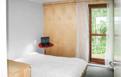 1 dormitorio con 1 cama y mesa roja con ordenador portátil en Amazing Home In Erslev With 3 Bedrooms And Wifi en Vester Jølby