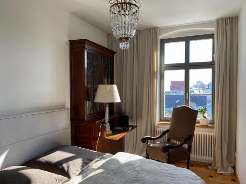 een slaapkamer met een bed, een stoel en een raam bij Altes Pfarrhaus in Papstdorf