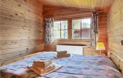 um quarto com uma cama num chalé de madeira em Gorgeous Home In Masserberg Ot Fehrenba With House A Panoramic View em Fehrenbach