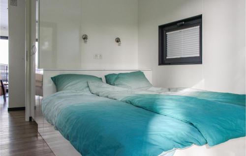 een groot bed met blauwe lakens in een slaapkamer bij Maasparel in Well