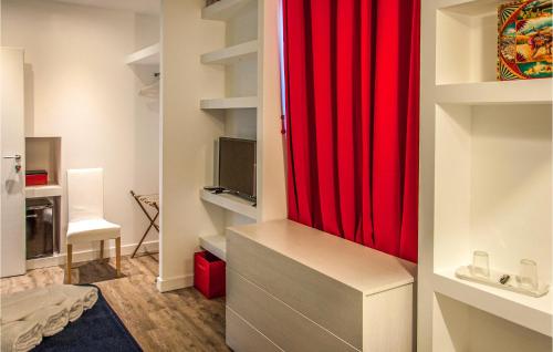 Habitación con armario rojo y TV. en Cozy Home In San Michele Di Ganzari With Kitchen, en San Michele di Ganzaria