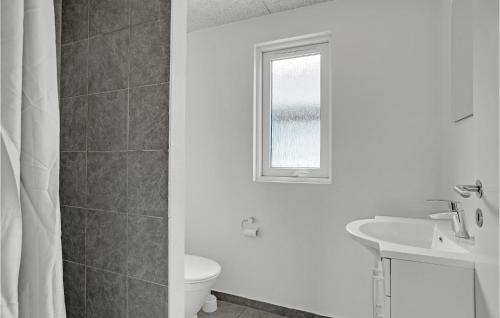 a bathroom with a toilet and a sink and a window at Amazing Home In Sydals With Indoor Swimming Pool in Høruphav