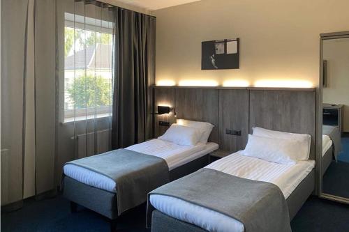 Cette chambre comprend 2 lits et une fenêtre. dans l'établissement Brut Wine Hotel, à Zarasai