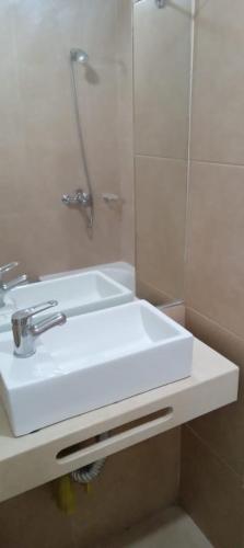y baño con lavabo blanco y espejo. en Temporario Lavalle en San Miguel de Tucumán