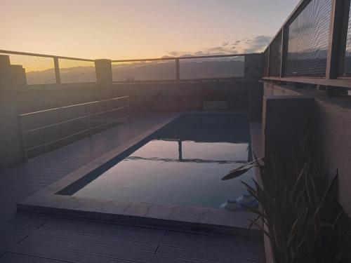 una piscina en la azotea de un edificio con puesta de sol en Temporario Lavalle en San Miguel de Tucumán