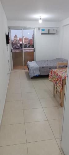 Habitación con cama en el suelo de baldosa en Temporario Lavalle en San Miguel de Tucumán