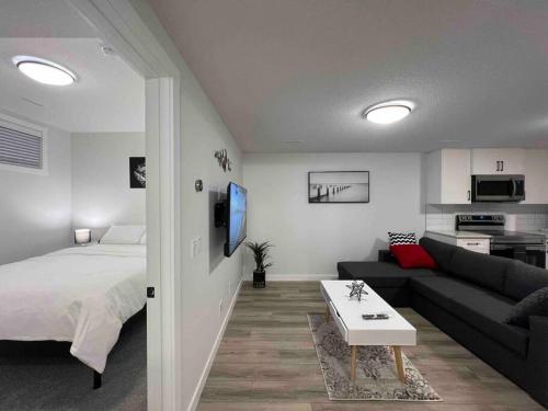 a living room with a bed and a couch at Cozy New Suite in NW Calgary in Calgary