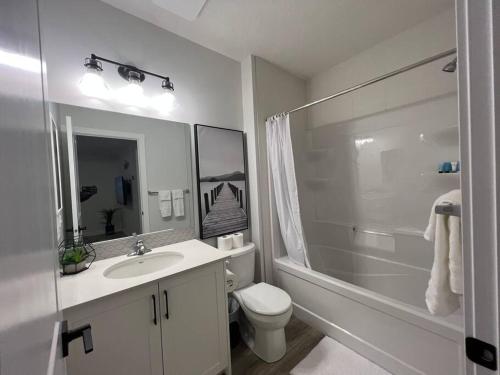 a bathroom with a sink and a toilet and a shower at Cozy New Suite in NW Calgary in Calgary
