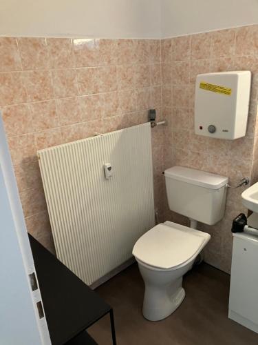 uma casa de banho com um WC branco e um radiador em 1 - Zimmer Appartement - kleine Harzperle em Langelsheim