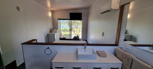ein Bad mit einem Waschbecken und einem Spiegel in der Unterkunft Narangba Motel (formerly Brisbane North B&B and Winery) in Narangba