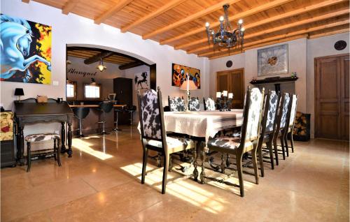 comedor con mesa, sillas y lámpara de araña en 6 Bedroom Beautiful Home In Vallabregues, en Vallabrègues