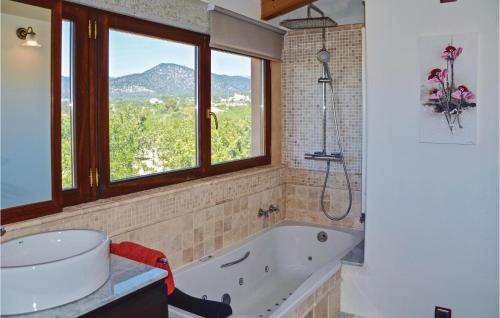 a bathroom with a tub and a window at Beautiful Home In Santa Maria With Private Swimming Pool, Outdoor Swimming Pool And Swimming Pool in Santa Maria del Camí