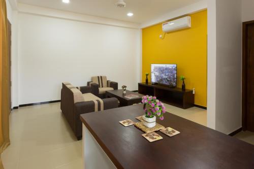 a living room with a couch and a table with flowers at Niwahas Apartments Kottawa in Pannipitiya