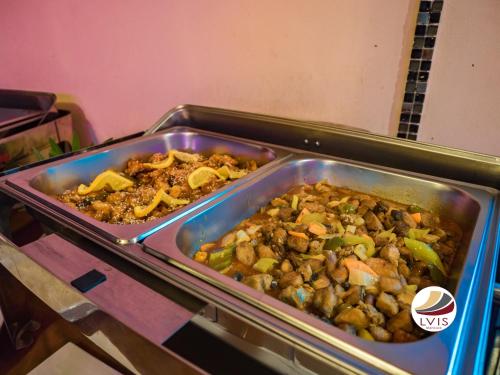 two trays of food on a buffet table at LVIS Village in Dharavandhoo