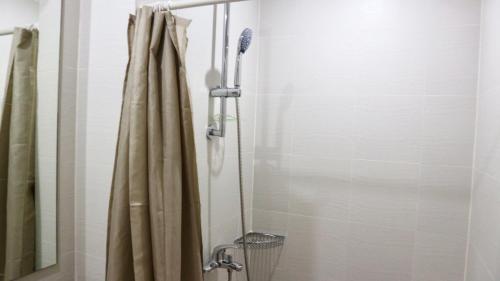 een douche in een badkamer met een douchegordijn bij Relaxing 1BR Sanctuary at Azure with Wi-Fi in Manilla