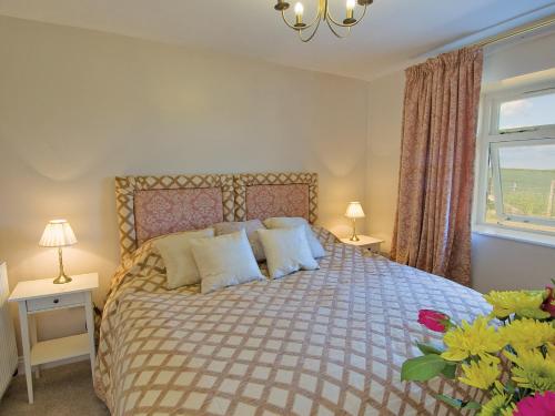 um quarto com uma cama com 2 candeeiros e uma janela em Lapwing Cottage - E5028 em Birtley