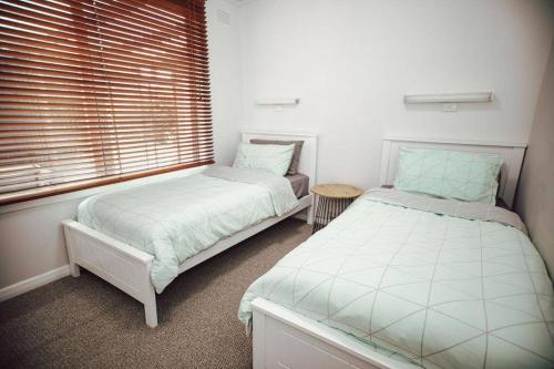 um quarto com 2 camas e uma janela em Ocean Blue em Peterborough