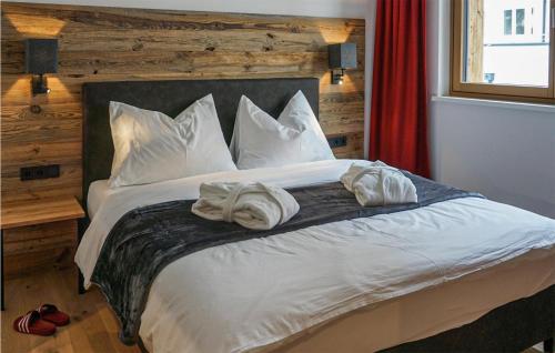 um quarto com uma cama grande com lençóis brancos e almofadas em 1 Bedroom Nice Apartment In Flachau em Flachau