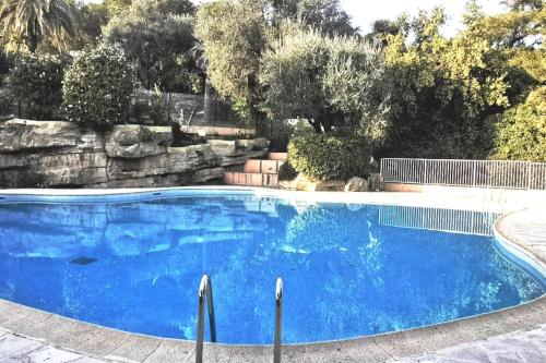 une grande piscine bleue dans une cour dans l'établissement Appartement Nice CENTRE vue Mer avec piscine pour FAMILLE, couple d'amis pas de groupes de jeunes autorisés, à Nice