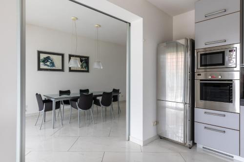 uma cozinha com uma mesa com cadeiras e um frigorífico em Villa Amalfi em Casalecchio di Reno