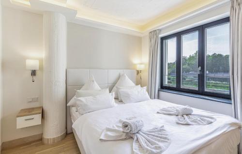 sypialnia z białym łóżkiem i dużym oknem w obiekcie Captn w mieście Binz