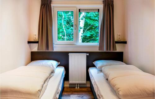 twee bedden in een kamer met twee ramen bij Chalet 84 in Oosterwolde