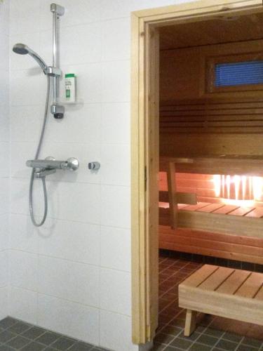 a shower in a bathroom with a bench in it at Apartment Marta in Vuokatti