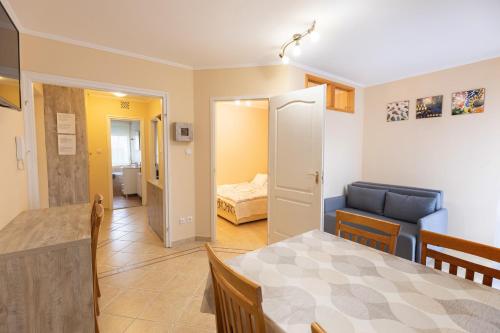 ハイドゥソボスローにあるMárta Apartmanのリビングルーム(ダイニングテーブル付)、ベッドルーム1室が備わります。