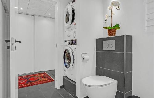 uma casa de banho com um WC e uma máquina de lavar roupa em 5 Bedroom Awesome Home In Ebeltoft em Ebeltoft