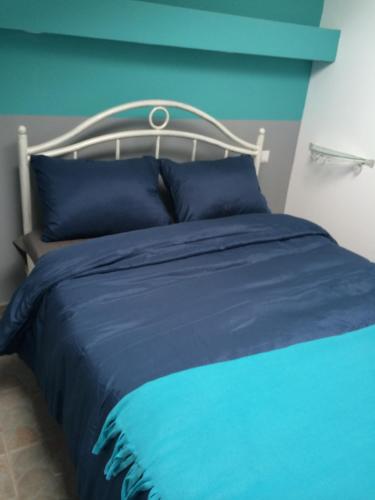 a blue bed with a white headboard and blue sheets at Retro Hostel in Cluj-Napoca