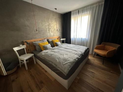 een slaapkamer met een bed, een stoel en een raam bij Designapartment 2.0 in Lutherstadt Wittenberg